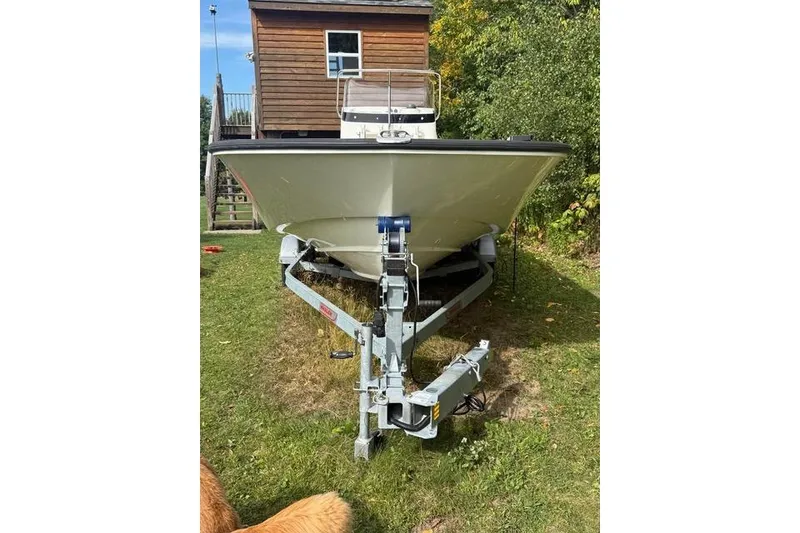 Slide: The Image of 2020 Boston Whaler 190 Montauk boat with console and steering wheel, parked on grass. - 5