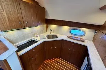 Slide: The Image of 2019 Tiara Yachts 4300 Open kitchen with wooden cabinetry and modern appliances. - 17