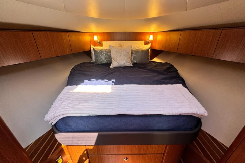 Slide: The Image of Luxurious cabin interior of 2019 Tiara Yachts 4300 Open with cozy bedding and warm lighting. - 18