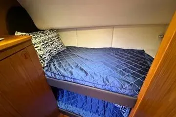 Slide: The Image of 2019 Tiara Yachts 4300 Open cabin with blue bedding and wooden interior. - 20