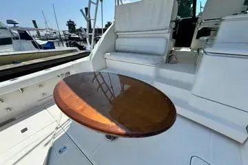 Slide: The Image of 2019 Tiara Yachts 4300 Open with polished wooden table and white seating. - 3