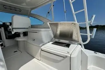 Slide: The Image of 2019 Tiara Yachts 4300 Open interior with seating and storage, docked by water. - 4