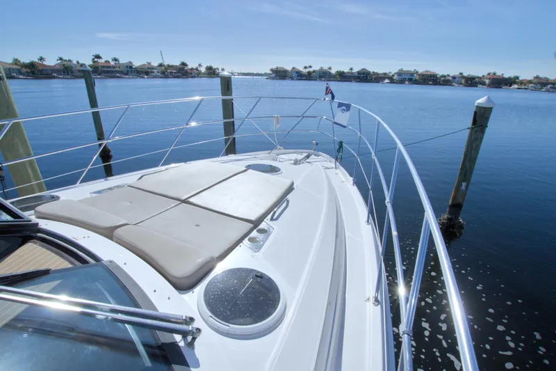 Slide: The Image of 2014 Regal 46 Sport Coupe yacht docked, featuring spacious sunbathing area and scenic waterfront view. - 16