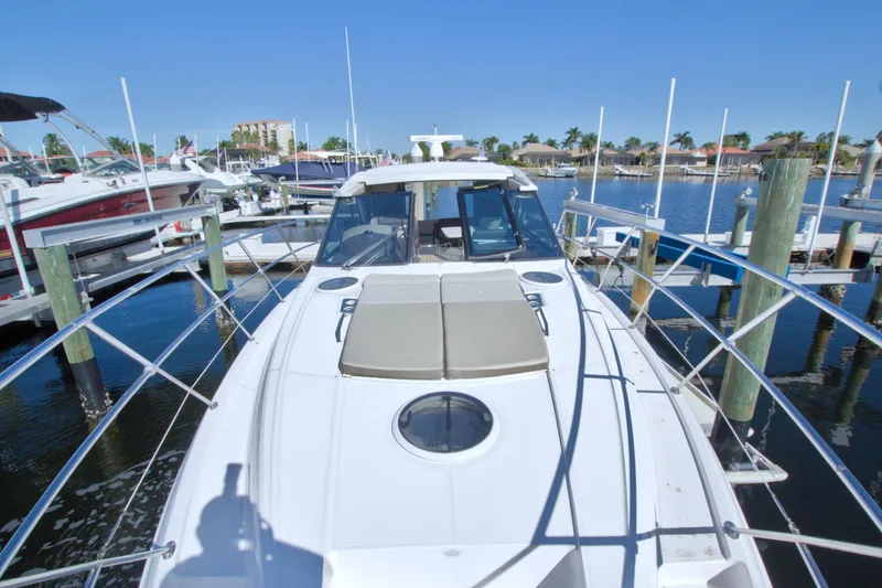 Slide: The Image of 2014 Regal 46 Sport Coupe yacht docked at marina under clear blue sky. - 18