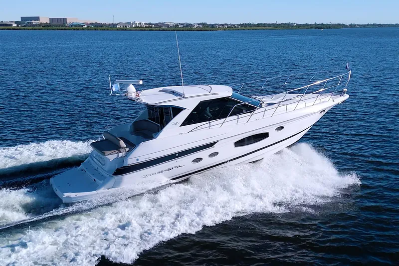 Slide: The Image of 2014 Regal 46 Sport Coupe cruising on open water, showcasing sleek design and performance. - 2
