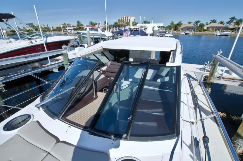 Slide: The Image of 2014 Regal 46 Sport Coupe yacht docked at marina under clear blue sky. - 20