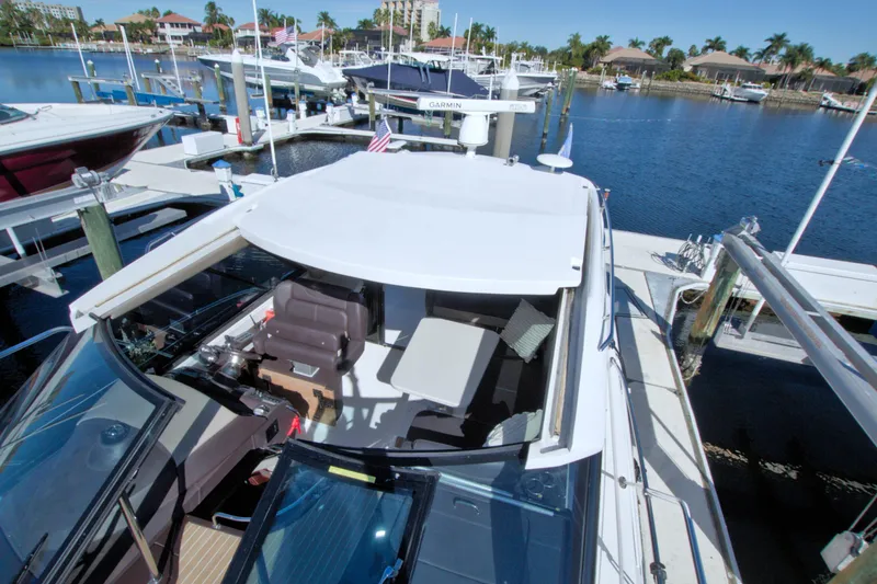 Slide: The Image of 2014 Regal 46 Sport Coupe docked at a marina, showcasing sleek design and spacious deck. - 21