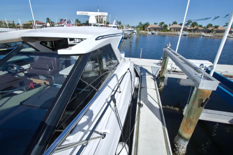 Slide: The Image of 2014 Regal 46 Sport Coupe docked at marina under clear blue sky. - 22