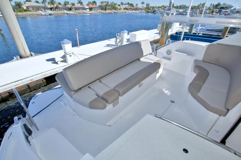Slide: The Image of 2014 Regal 46 Sport Coupe yacht with spacious seating, docked by a serene waterfront. - 24