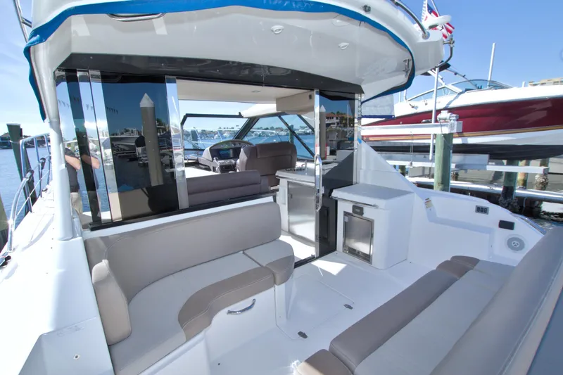 Slide: The Image of 2014 Regal 46 Sport Coupe yacht interior with seating and helm, docked at marina. - 27