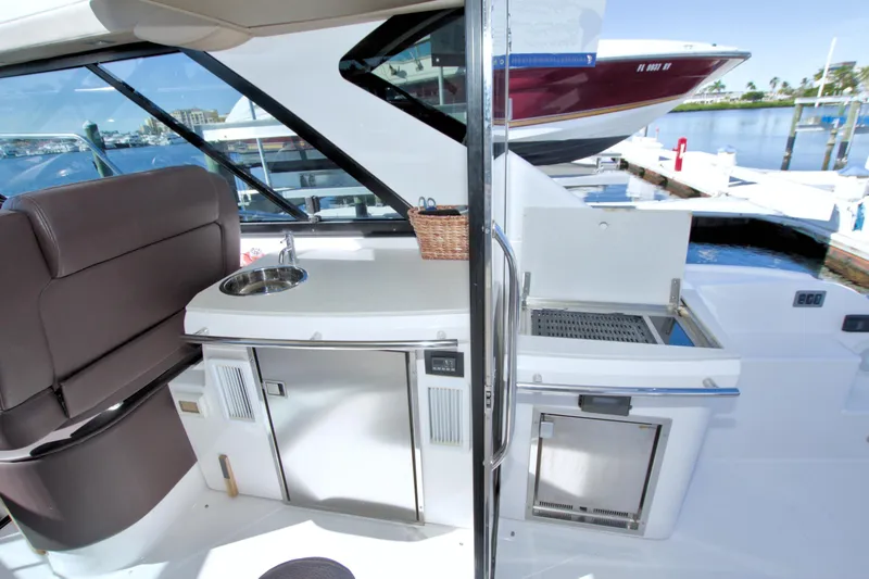 Slide: The Image of 2014 Regal 46 Sport Coupe yacht interior with kitchenette and seating area. - 28