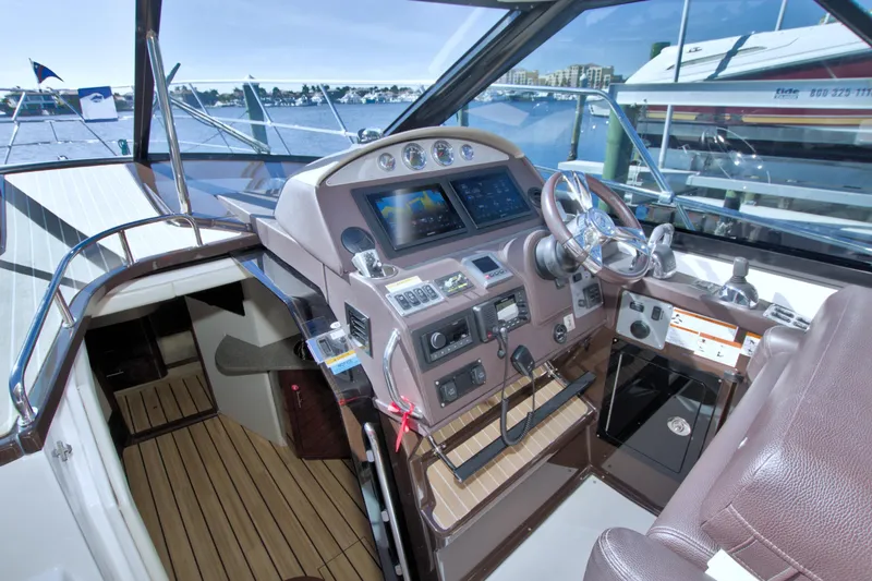 Slide: The Image of 2014 Regal 46 Sport Coupe helm with modern controls and waterfront view. - 33
