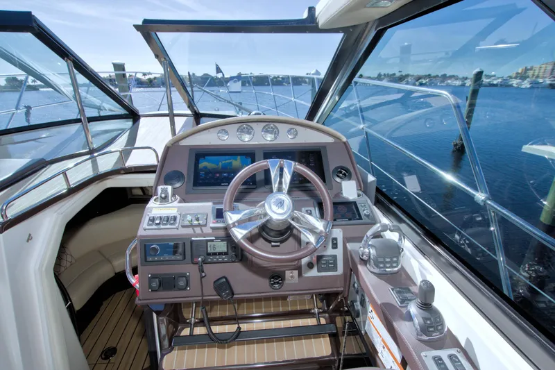 Slide: The Image of Cockpit view of 2014 Regal 46 Sport Coupe yacht with steering wheel and navigation controls. - 37