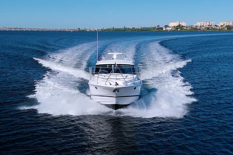 Slide: The Image of 2014 Regal 46 Sport Coupe cruising on open water, creating a dynamic wake. - 4