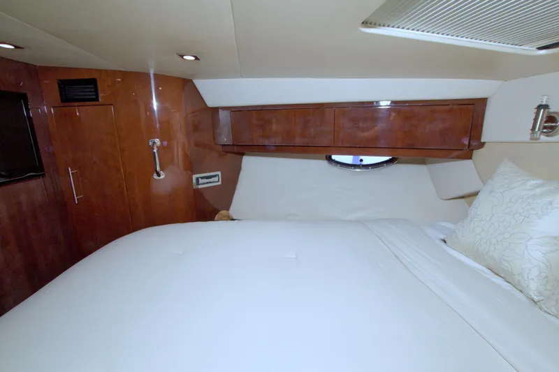 Slide: The Image of Luxurious cabin interior of 2014 Regal 46 Sport Coupe with wood paneling and plush bedding. - 45
