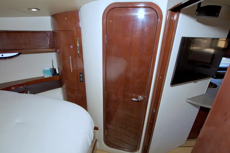 Slide: The Image of 2014 Regal 46 Sport Coupe interior with wood finish, TV, and cozy cabin space. - 47