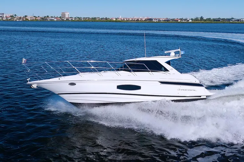 Slide: The Image of 2014 Regal 46 Sport Coupe cruising on open water, showcasing sleek design and performance. - 5