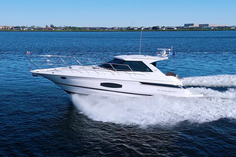 Slide: The Image of 2014 Regal 46 Sport Coupe cruising on a serene blue lake. - 6