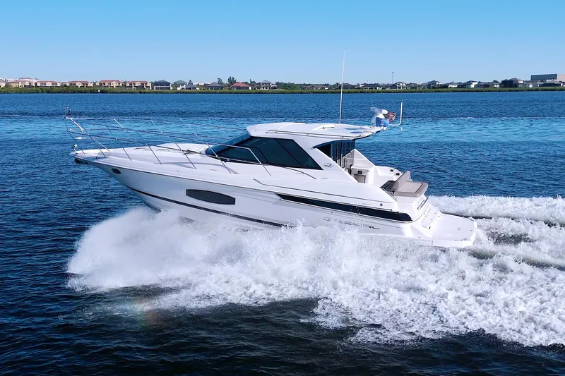 Slide: The Image of 2014 Regal 46 Sport Coupe cruising on open water, showcasing sleek design and performance. - 7
