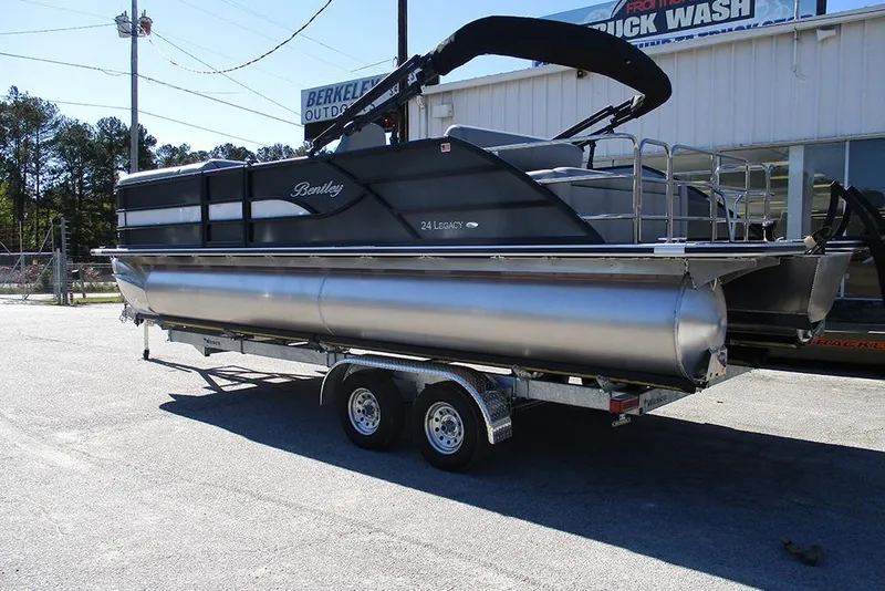 Slide: The Image of 2026 Bentley Pontoons Legacy 243 Swingback on trailer, parked outdoors near dealership. - 2