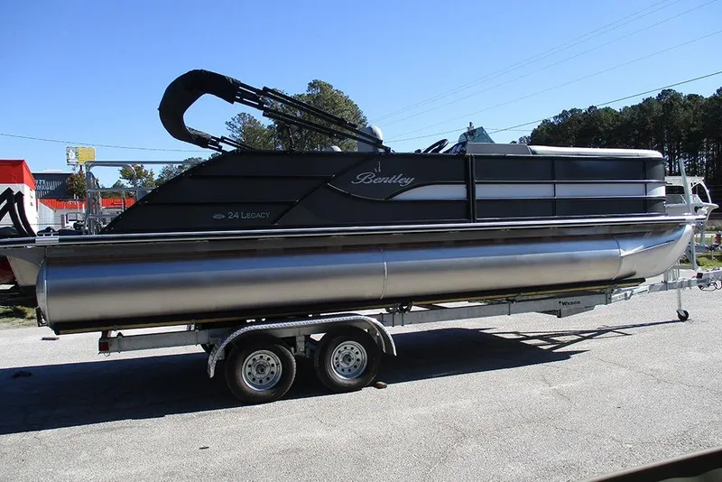 Slide: The Image of 2026 Bentley Pontoons Legacy 243 Swingback on trailer, sleek design, parked outdoors. - 6
