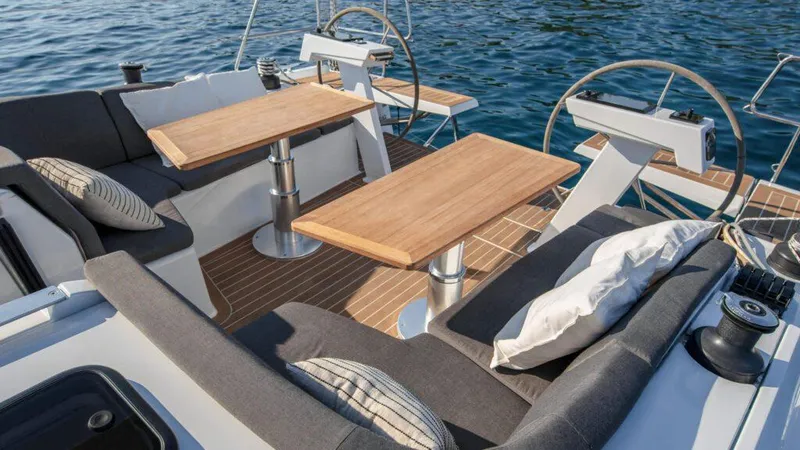 Slide: The Image of Luxurious 2025 Hanse 410 yacht deck with elegant seating and wooden tables. - 4