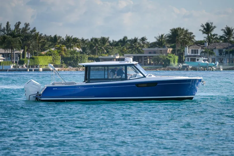 The Image of Blue 2026 MJM 3 boat cruising on a sunny day near a coastal area. - 0