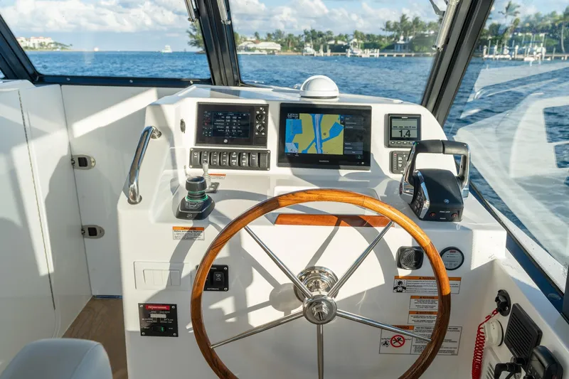 Slide: The Image of Helm of 2026 MJM 3 boat with navigation screens and wooden steering wheel. - 15