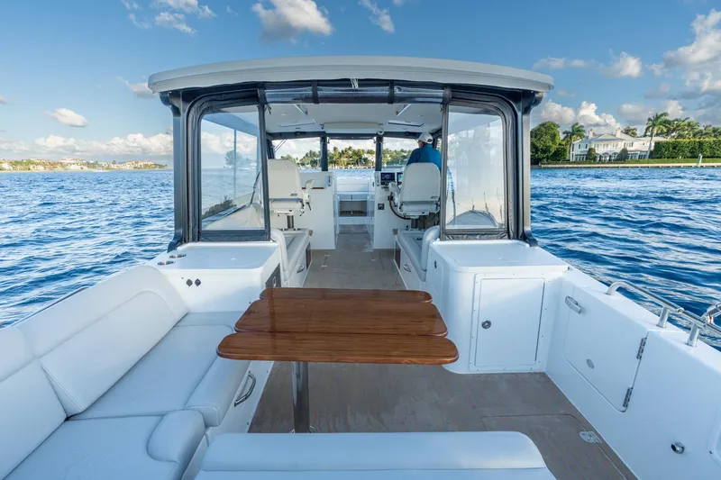 Slide: The Image of 2026 MJM 3 boat interior with seating and table on a sunny day. - 9