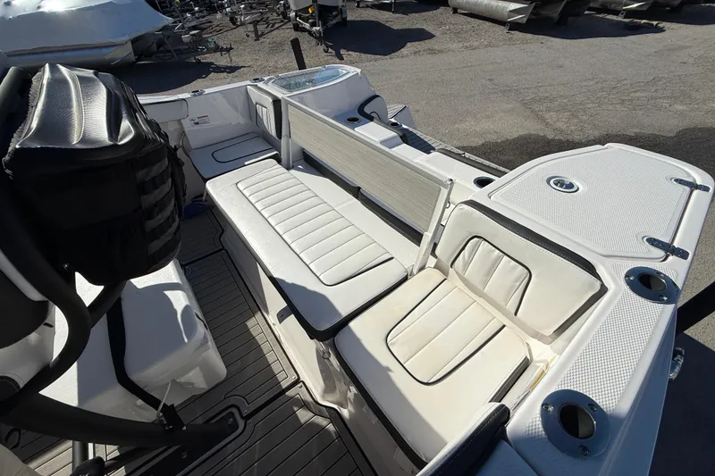 Slide: The Image of 2024 Yamaha Boats 255 FSH Sport H interior seating with white upholstery and storage compartments. - 12