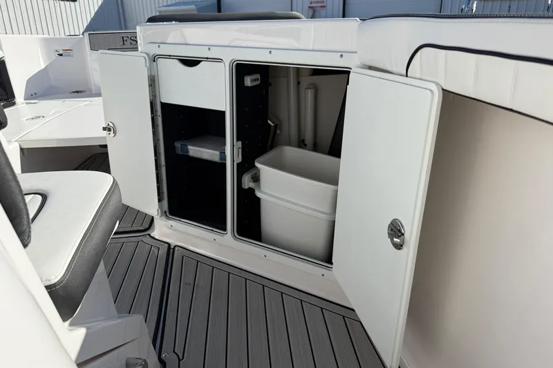 Slide: The Image of 2024 Yamaha Boats 255 FSH Sport H interior storage compartments open on deck. - 18