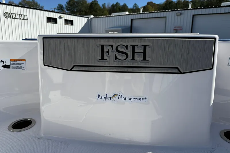 Slide: The Image of 2024 Yamaha Boats 255 FSH Sport H with "Angler Management" decal, outdoor setting. - 21