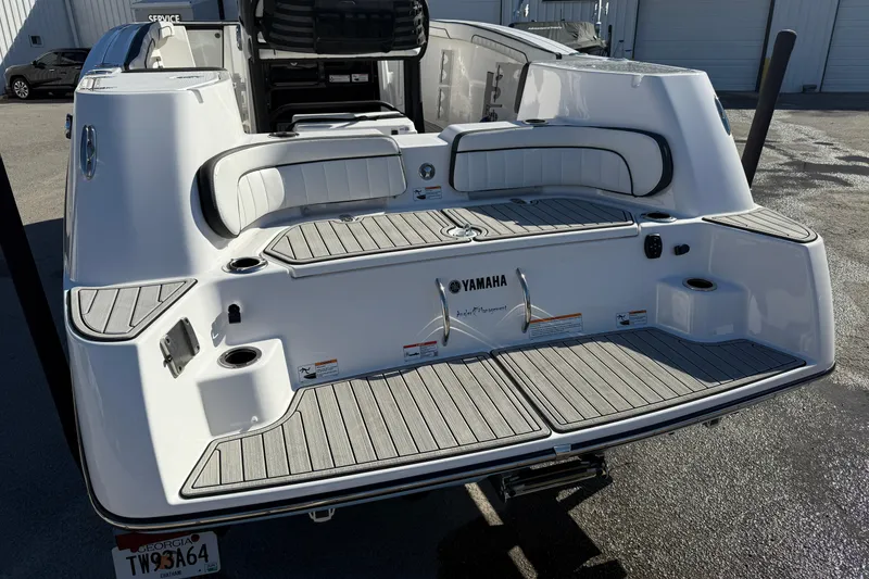 Slide: The Image of 2024 Yamaha Boats 255 FSH Sport H, rear view, showcasing spacious deck and seating. - 22