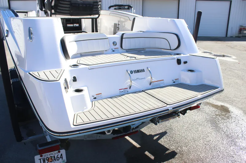 Slide: The Image of 2024 Yamaha Boats 255 FSH Sport H, rear view, white exterior, docked on trailer. - 3
