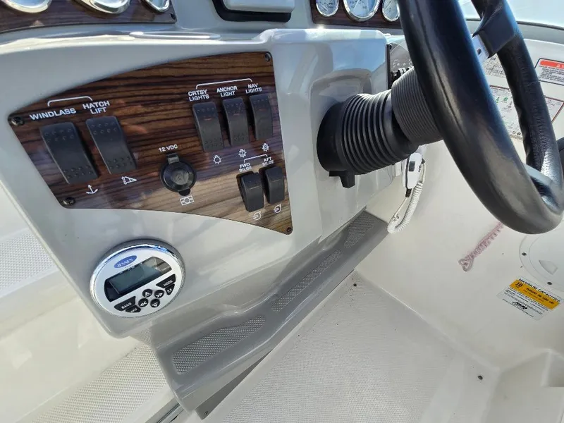 Slide: The Image of Control panel of a 2011 Bayliner 255 boat with steering wheel and switches. - 12