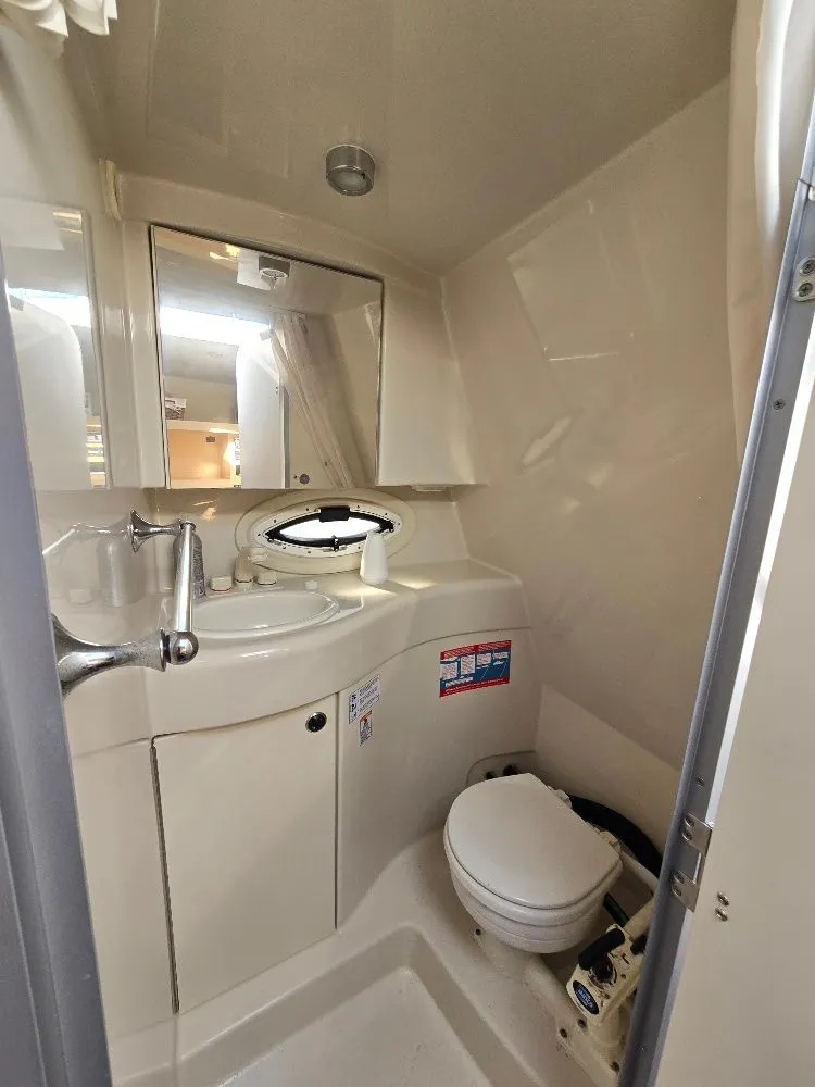 Slide: The Image of 2011 Bayliner 255 boat bathroom with sink, toilet, and mirror. - 16