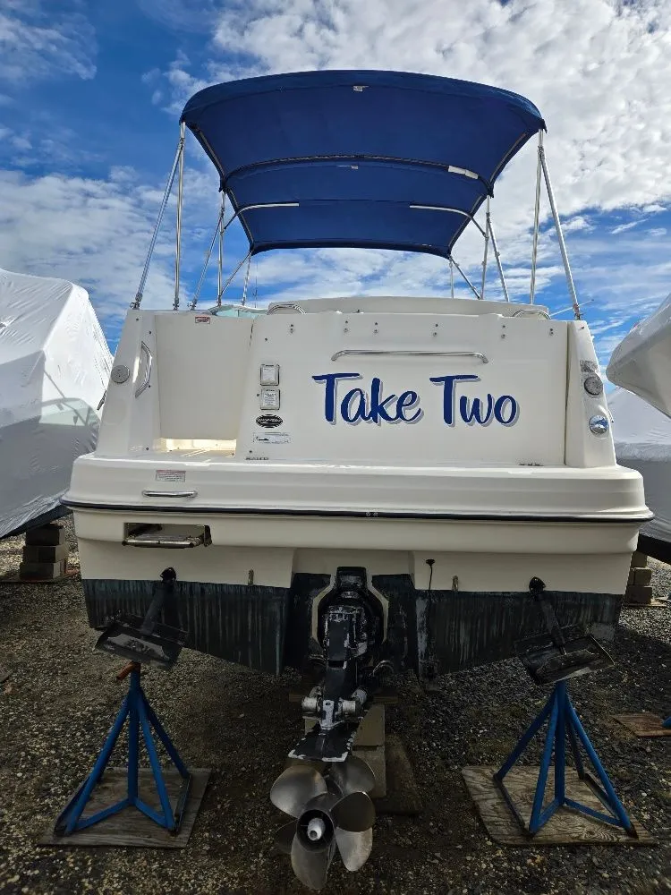 Slide: The Image of 2011 Bayliner 255 boat named "Take Two" with blue canopy, on stands. - 4