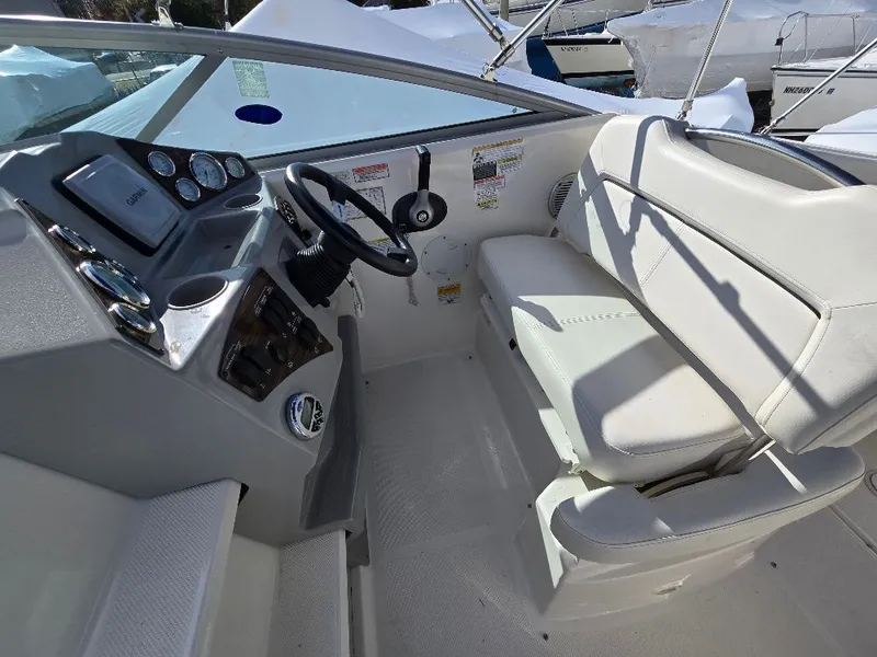 Slide: The Image of 2011 Bayliner 255 boat cockpit with steering wheel and seating area. - 8