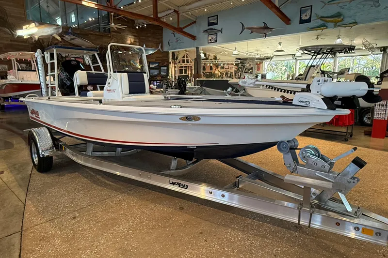 Slide: The Image of 2026 Mako 18 Pro Skiff Patriot Edition boat on display in a showroom. - 1
