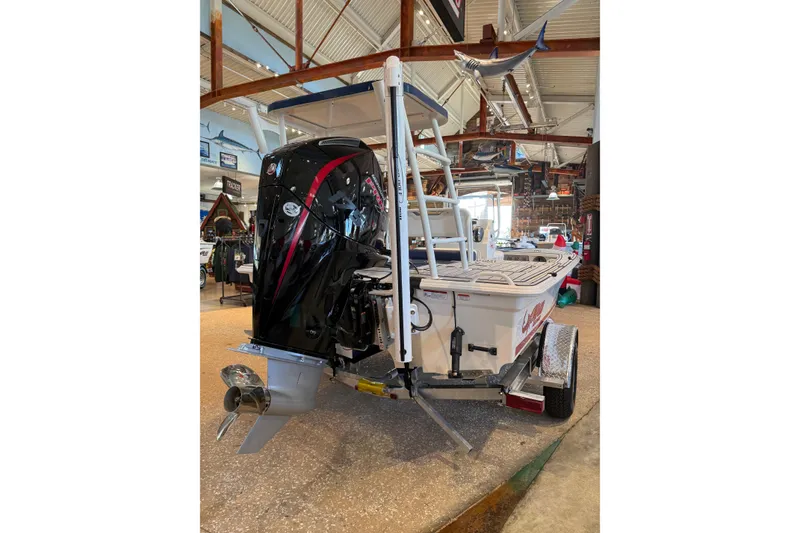 Slide: The Image of 2026 Mako 18 Pro Skiff Patriot Edition boat displayed indoors, showcasing its powerful outboard motor. - 4