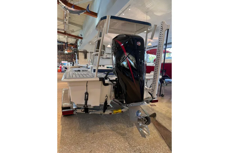 Slide: The Image of 2026 Mako 18 Pro Skiff Patriot Edition boat displayed indoors, rear view. - 5