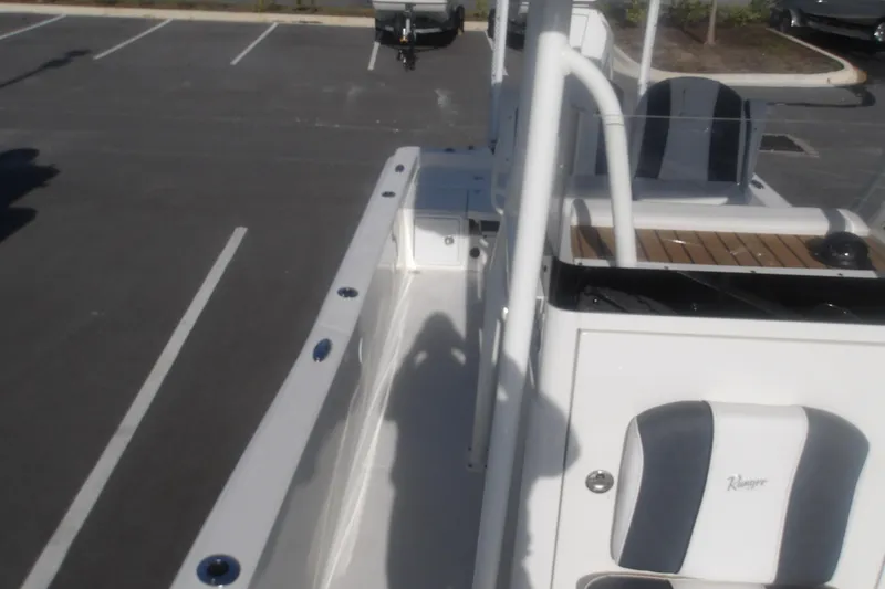 Slide: The Image of 2026 Ranger 2510 Bay boat interior with seating and console in a parking lot. - 31