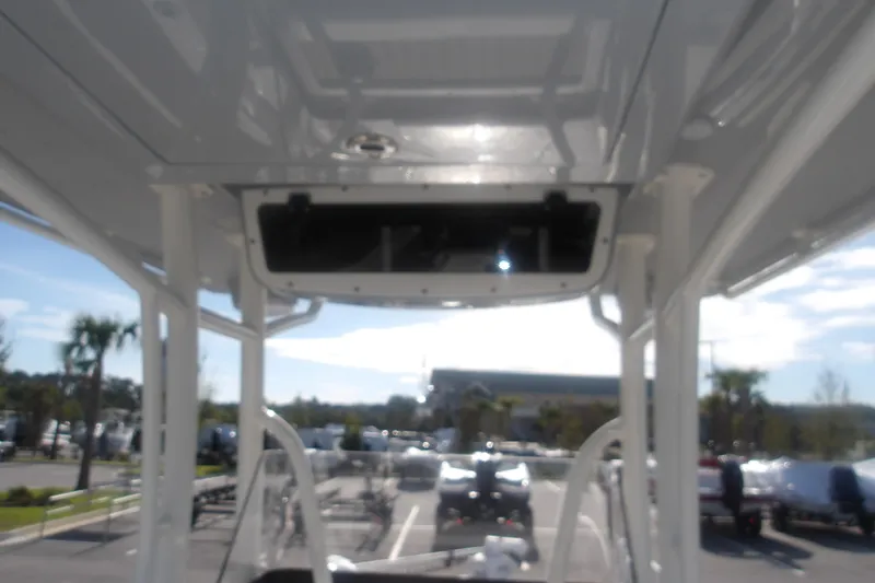 Slide: The Image of 2026 Ranger 2510 Bay boat interior view with overhead compartment, parked outdoors. - 23