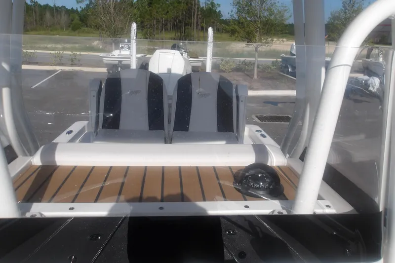 Slide: The Image of 2026 Ranger 2510 Bay boat interior with seating and compass, parked outdoors. - 28