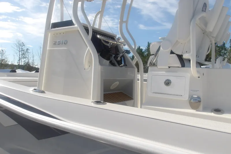 Slide: The Image of 2026 Ranger 2510 Bay boat interior with steering console and seating, under a clear sky. - 15