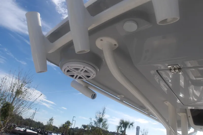 Slide: The Image of 2026 Ranger 2510 Bay boat roof with rod holders and speaker, under clear sky. - 22