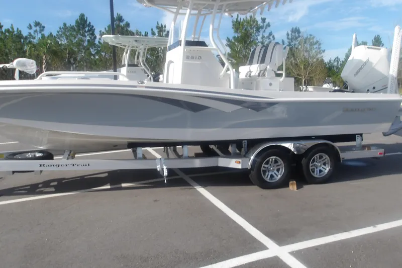 Slide: The Image of 2026 Ranger 2510 Bay boat on trailer in parking lot, clear sky background. - 2