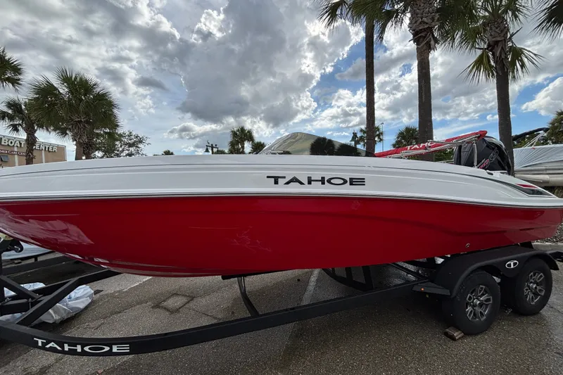 Slide: The Image of 2026 Tahoe T21 boat in red and white on a trailer, parked outdoors. - 10