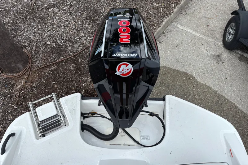 Slide: The Image of 2026 Tahoe T21 boat with Mercury 200 outboard motor, parked on pavement. - 5