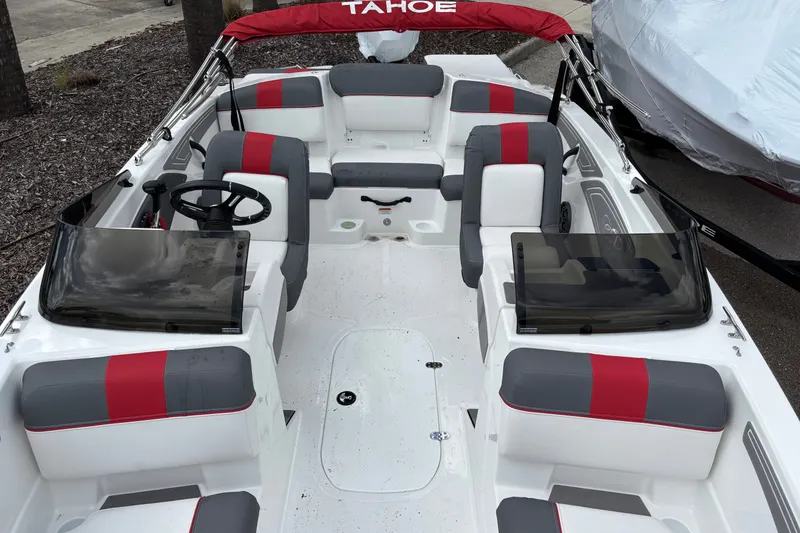Slide: The Image of 2026 Tahoe T21 boat interior with red and gray seating, steering wheel, and windshield. - 8